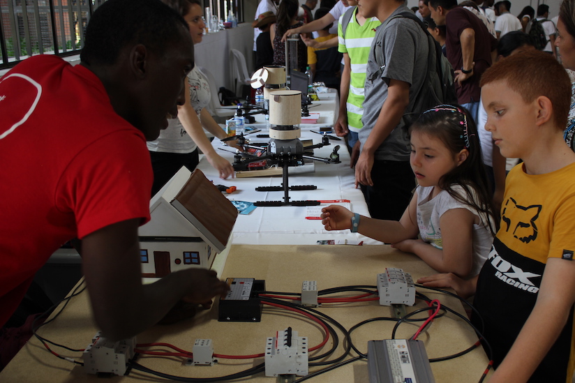 Monitor les enseña a dos niños el funcionamiento de la corriente eléctrica. Foto: Jhon Gamboa