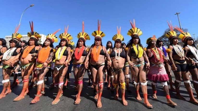 Mujeres indígenas protestando en Brasil por las políticas de Bolsonaro, a propósito de la crisis del Amazonas. Foto: http://www.resumenlatinoamericano.org/2019/08/23/brasil-mujeres-indigenas-defienden-el-amazonas-y-denuncian-a-bolsonaro-video/