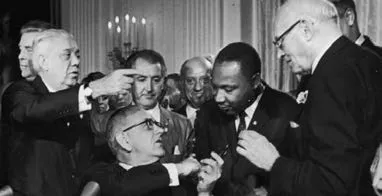 El presidente Lyndon B. Johnson estrechando la mano de Martin Luther King tras firmar el acta de los Derechos Civiles en Washington D.C., el 2 de julio de 1964. - Foto: https://www.infobae.com 
